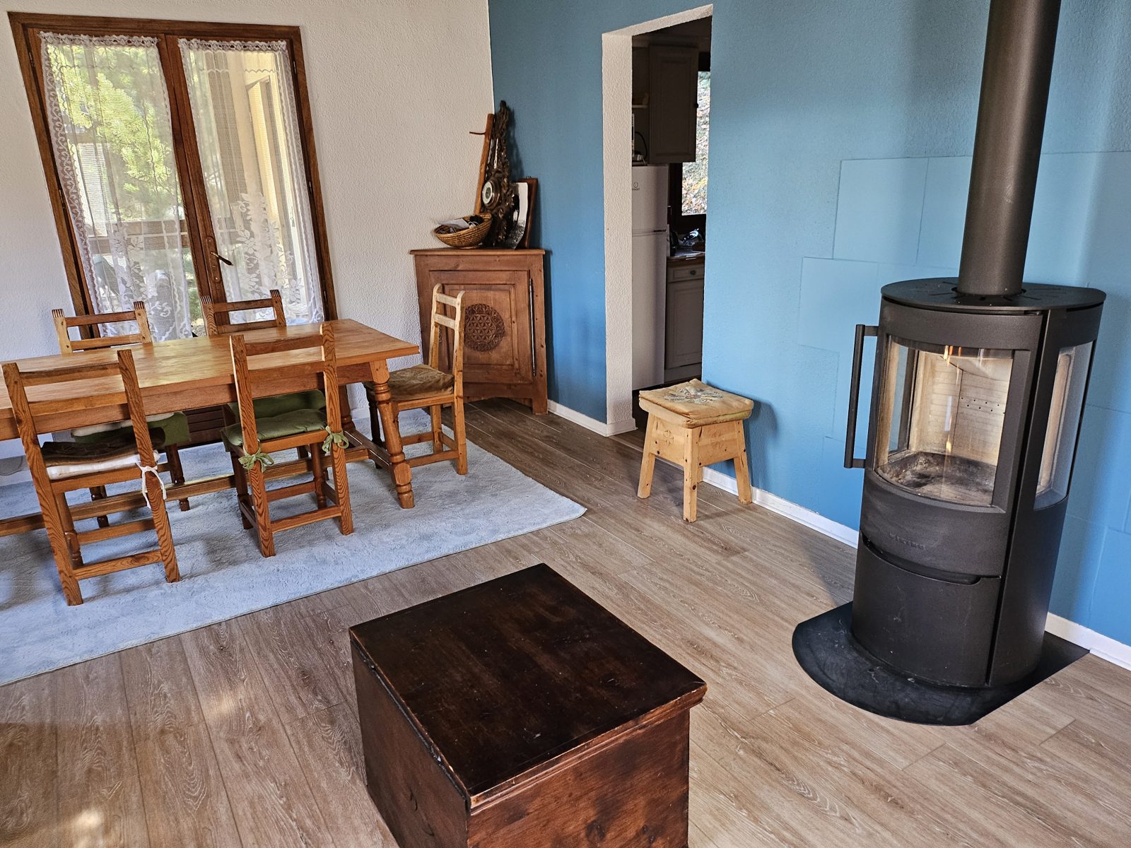 Salle à manger du chalet avec grande table et poêle à bois