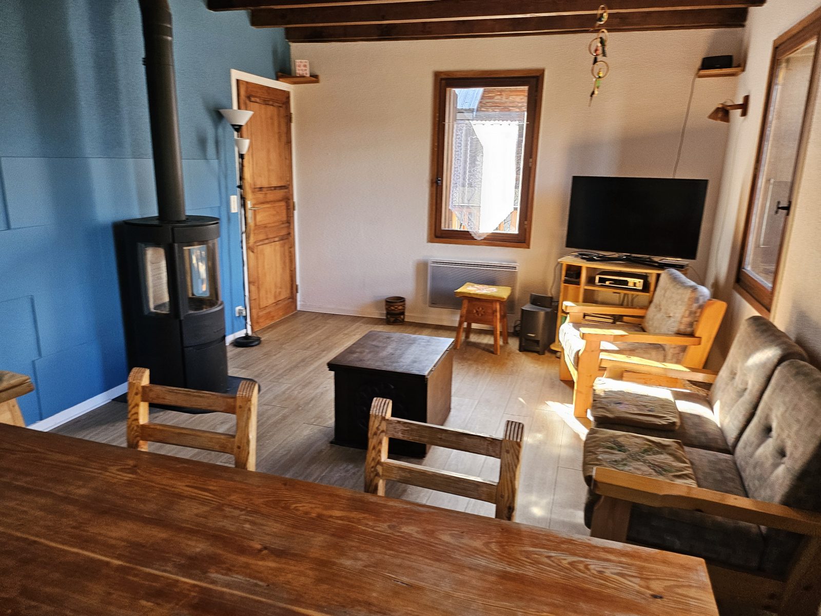 Séjour du chalet avec canapé, TV et poêle à bois